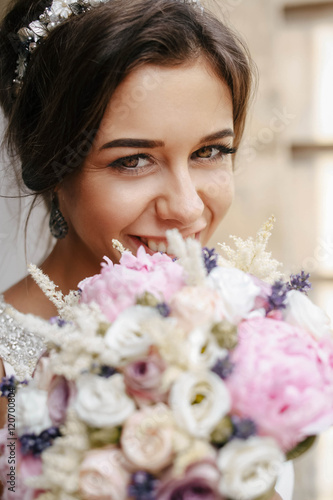 gentle bride holding a beautiful bouquet of flowers