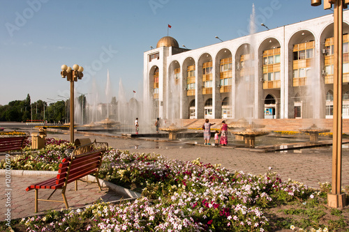 People walking around fountains at the country's main square Ala-Too in Bishkek, Kyrgyzstan. photo