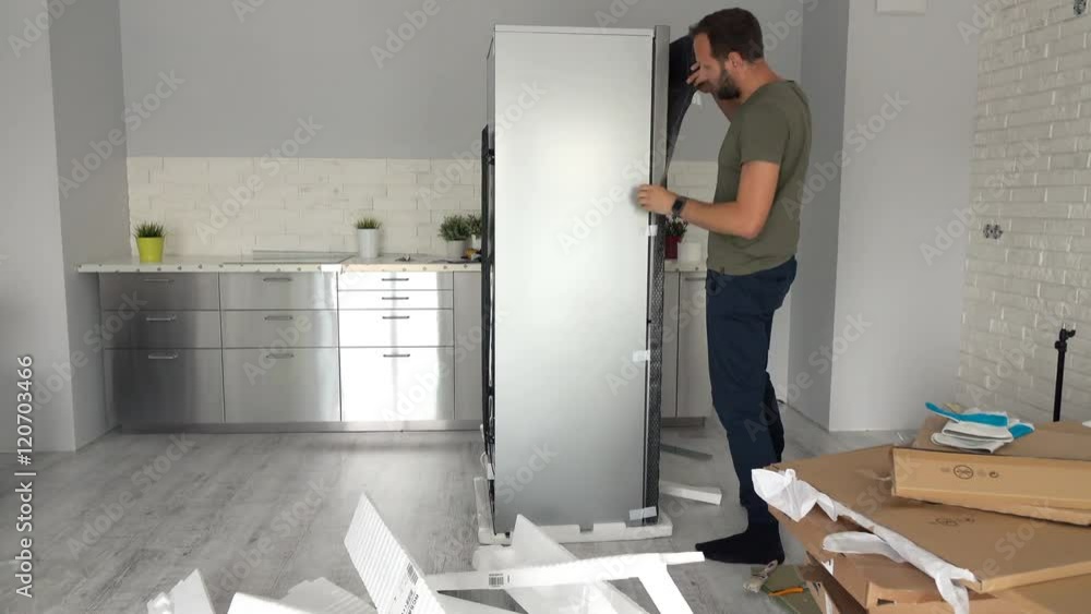 Young man unpacking new fridge from box at home, timelapse
Young man unpacking new fridge from box at home, timelapse