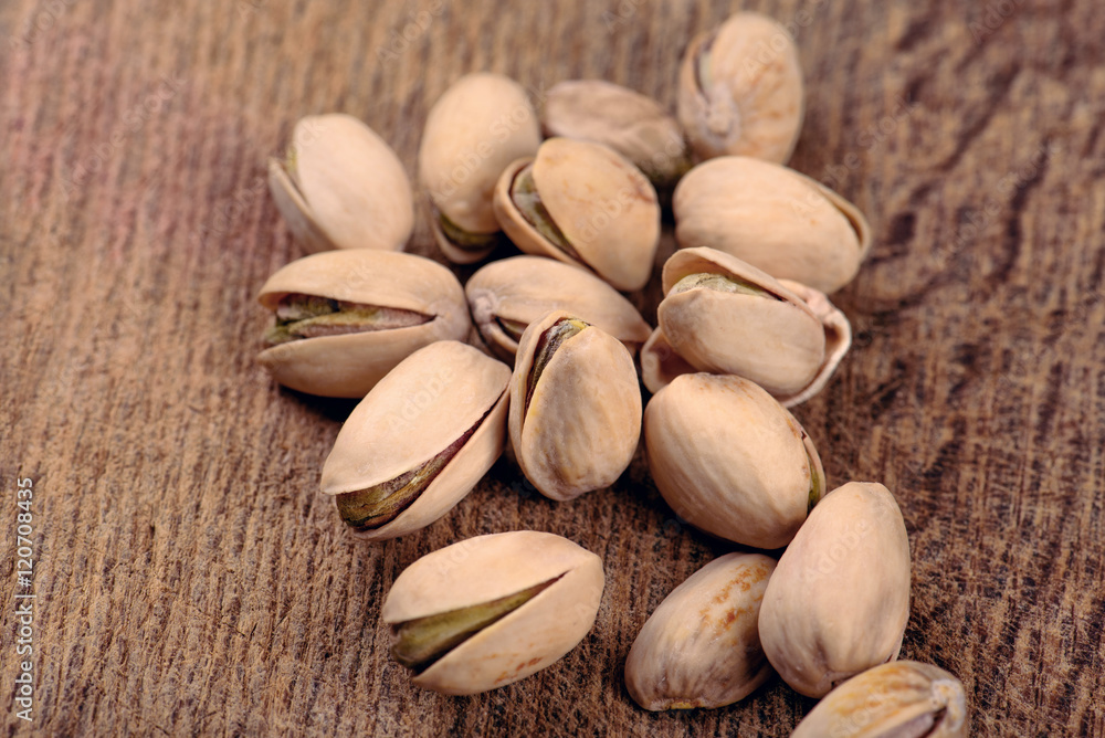pistachios on a wooden table closeup top view pistachios on a wooden table closeup top view