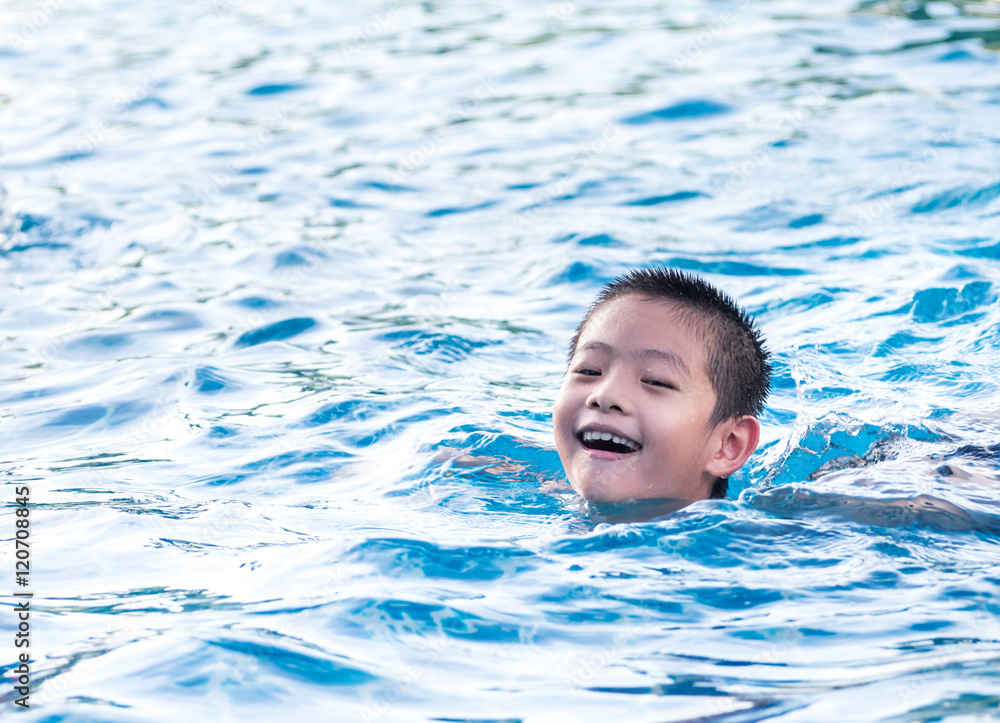 Asian boy is playing in the pool, float
