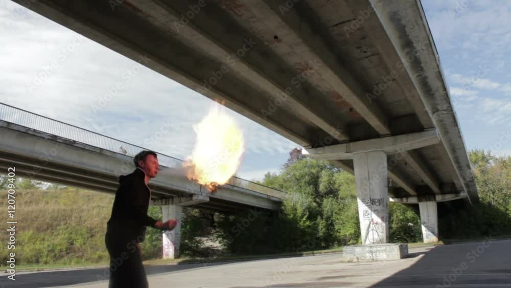 The fire eater, spitting fire.