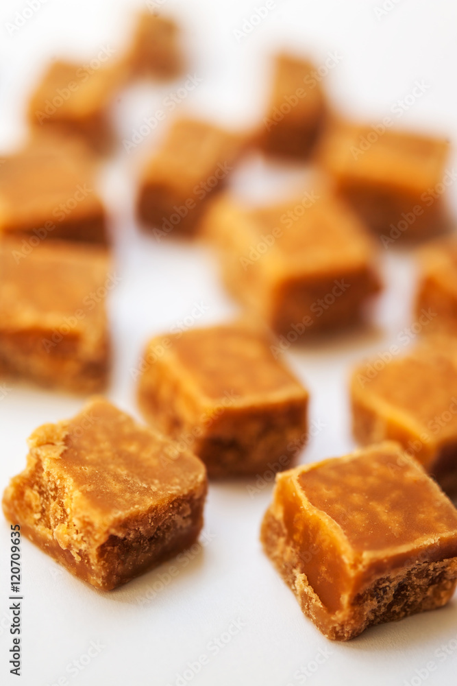 Caramel candies on brown background. Salted caramel pieces and s Caramel candies on brown background. Salted caramel pieces and s