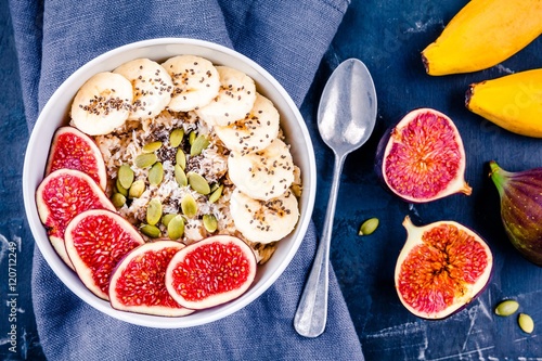 healthy breakfast: oatmeal with fresh figs, bananas, pumpkin seeds, coconut and chia seeds