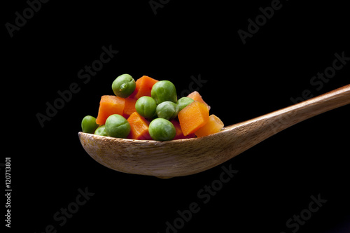 Mixed vegetables on wooden spoon.