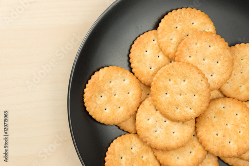 crackers cheese and crackers sugar in black plate on wood table