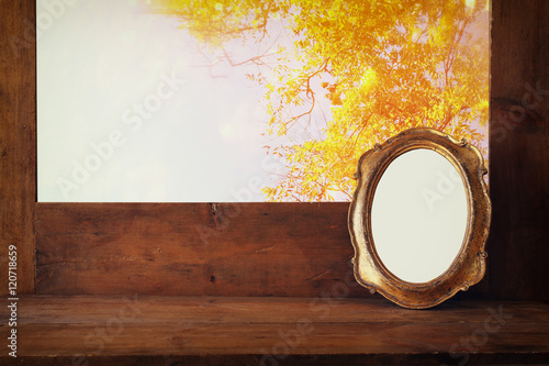 Golden old blank frame on wooden window sill