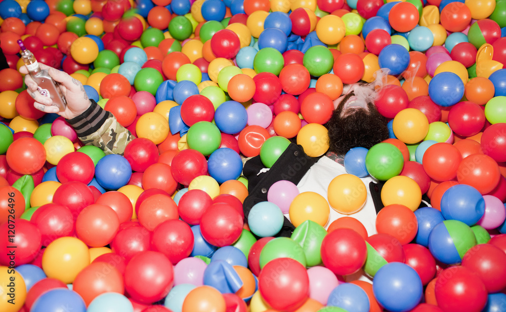 Young man playing in a ball pit Young man playing in a ball pit