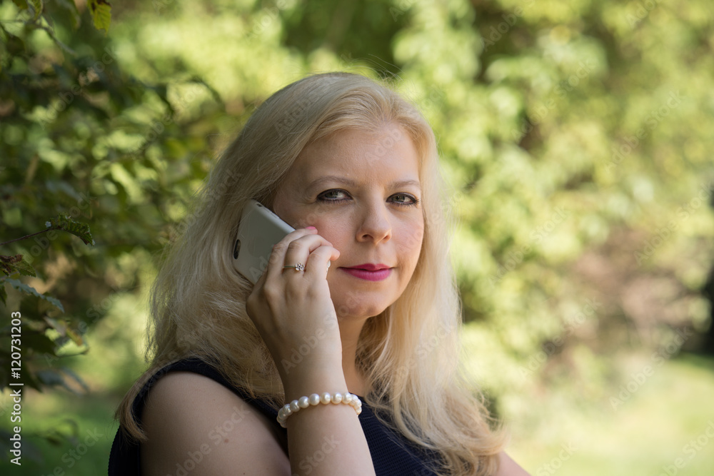 Blonde Frau telefoniert mit dem iPhone Blonde Frau telefoniert mit dem iPhone