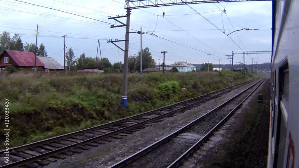 Train passing by a small village and railway station Train passing by a small village and railway station