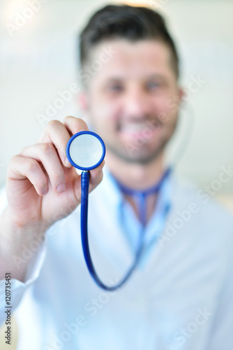 Portrait of man doctor at hospital corridor, looking at camera