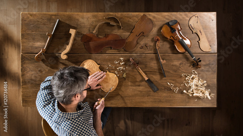 Top view. Artisan luthier working on the creation of a violin