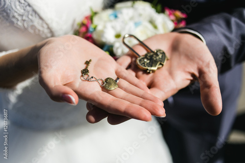 Decorative wedding lock and keys with coulomb in hands.