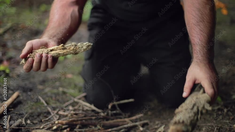 A male camper breaks off a stick for kindling in slow motion. A male camper breaks off a stick for kindling in slow motion.