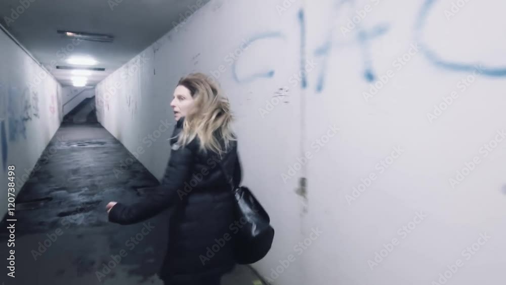 frightened scared woman in panic running away from murdered rapist bad man back view horror dark mood