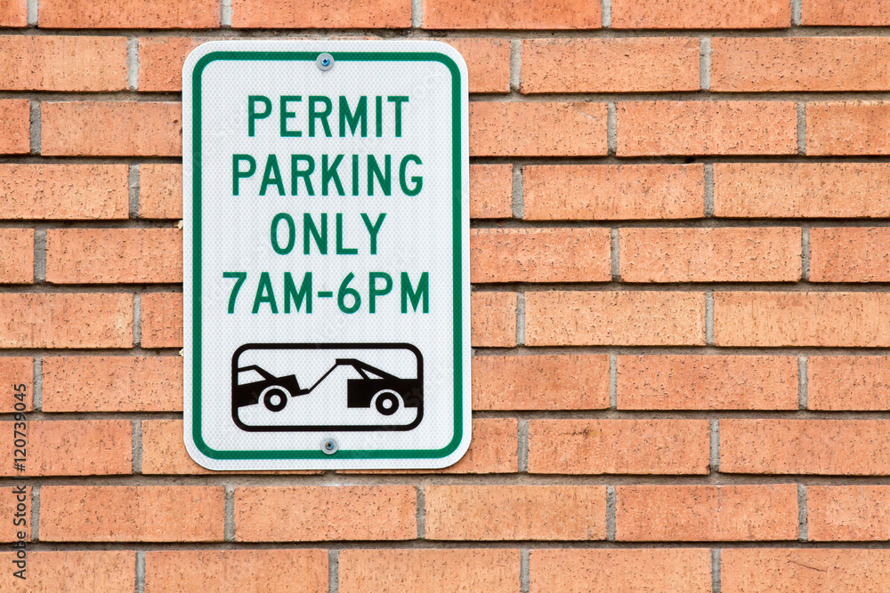Permit Parking only 7 am to 6 pm sign on a brick wall Permit Parking only 7 am to 6 pm sign on a brick wall