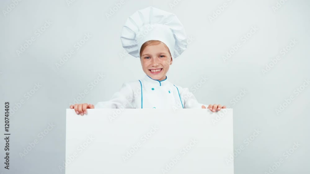 Portrait cute little chef cook in cap with white board isolated on white smiling at camera with teeth. Thumb up. Ok Portrait cute little chef cook in cap with white board isolated on white smiling at camera with teeth. Thumb up. Ok