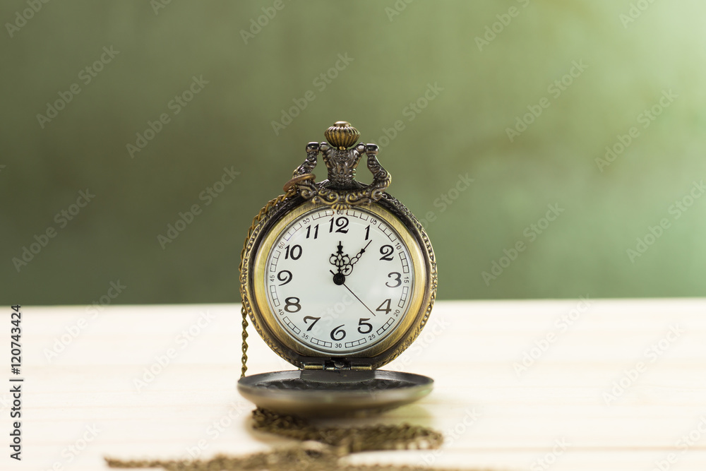 Still life antique clock placed on a wooden floor and a red shotgun shell with human skull on the back. Still life antique clock placed on a wooden floor and a red shotgun shell with human skull on the back.