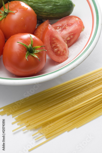 Spaghetti and Fresh Red Tomatoes with Cucumbers in the Background