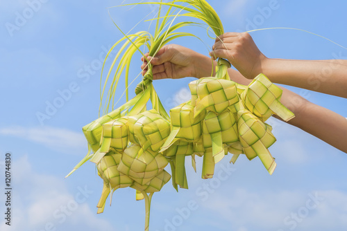 Wallpaper Mural A hand holding Ketupat - Malay cuisine made from glutinous rice packed inside a diamond shaped container of wooven palm leaf. Torontodigital.ca