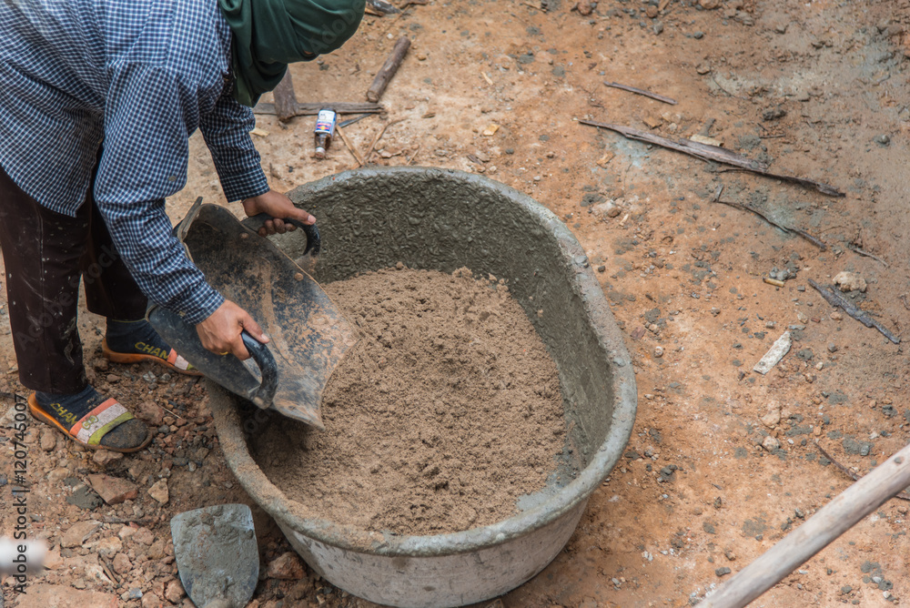 Obraz premium Construction work mixing cement in salver for applying construction