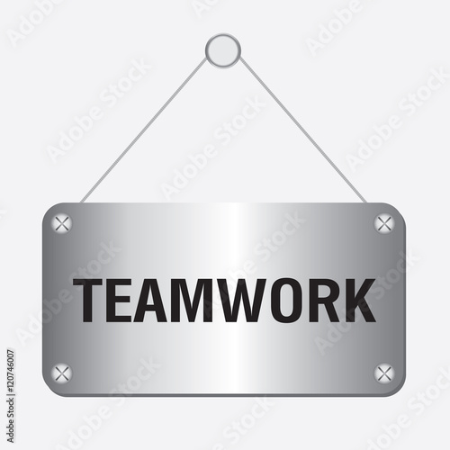 silver metallic teamwork sign hanging on the wall 