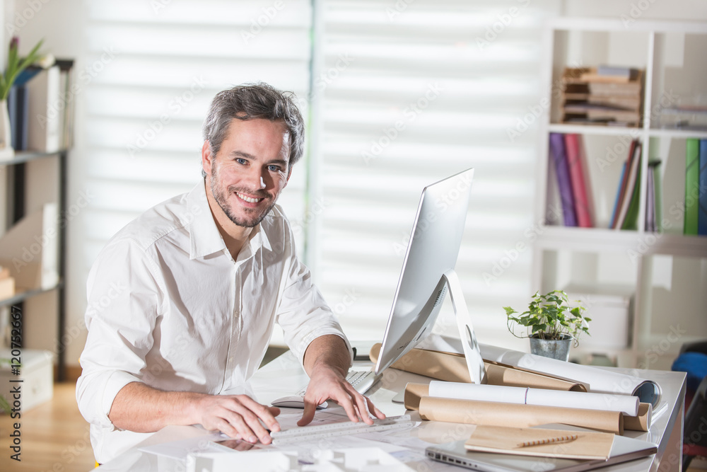 An architect sitting at office and working an a building project An architect sitting at office and working an a building project
