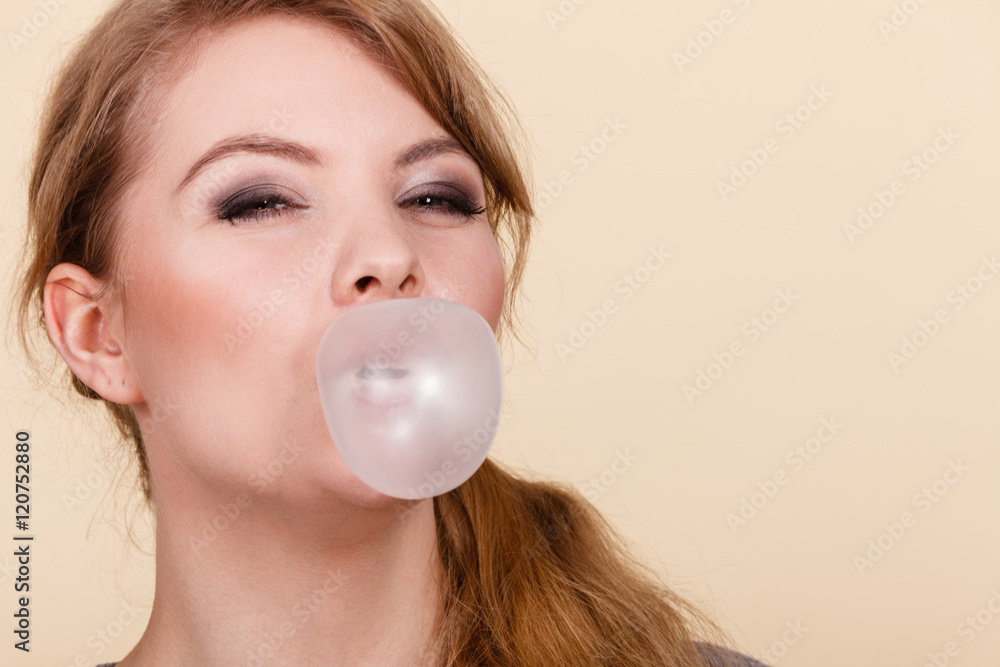 Blonde girl chewing gum making balloon. Blonde girl chewing gum making balloon.