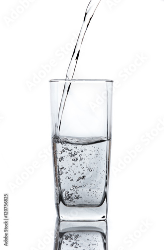 pouring water on glass on white background