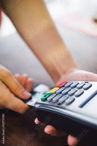 Closeup. Female hand inserts the credit card into the terminal