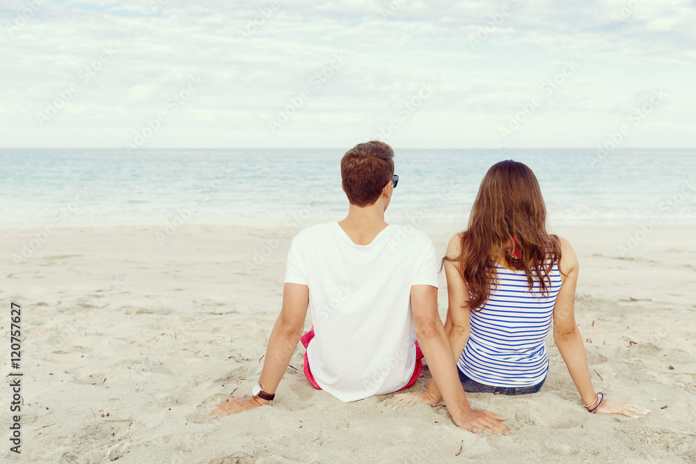Fototapeta premium Romantic young couple sitting on the beach