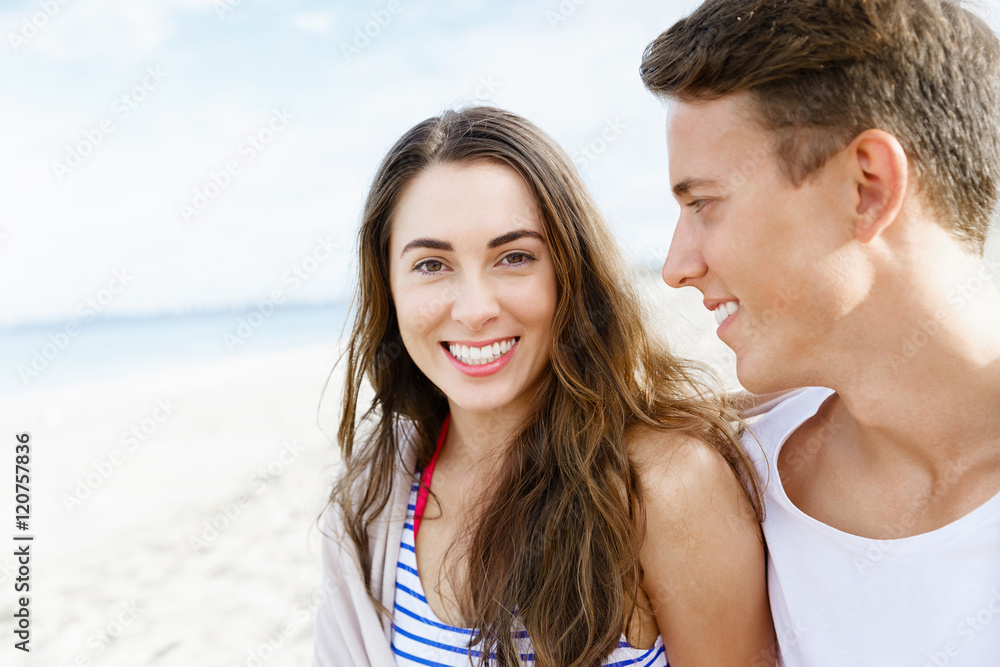 Romantic young couple sitting on the beach Romantic young couple sitting on the beach