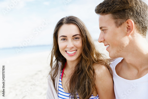 Romantic young couple sitting on the beach © Sergey Nivens