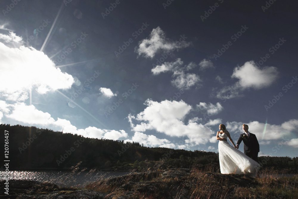 Fototapeta premium Bride and groom walking on the river