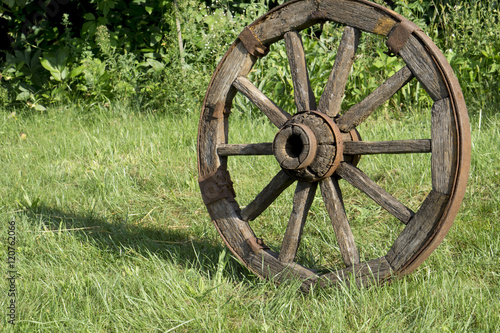 wooden wheel on a background of green grass