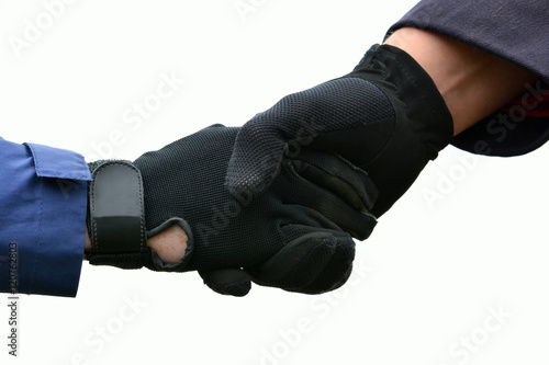 Two Caucasian equestrian hands with black horse riding gloves shaking showing sportsmanship. Image isolated on white studio background.