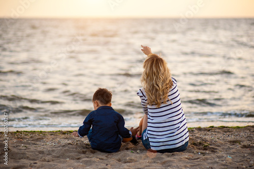 Fotografía Beautiful woman with a child of four years playing on the beach near the sea