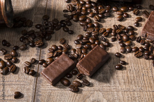 Coffee and chocolate/Coffee beans and chocolate on the wood background.