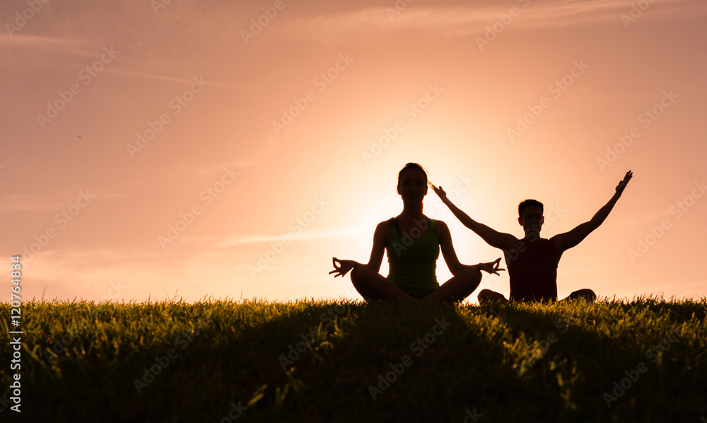 Young couple meditating outdoors. 