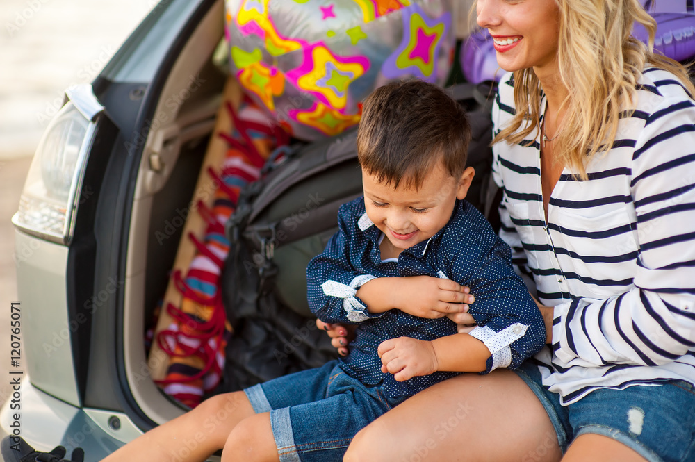 Beautiful woman with a child of four years in the car are going to have a trip