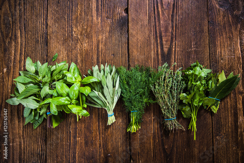 mixed herbs lay on wooden table