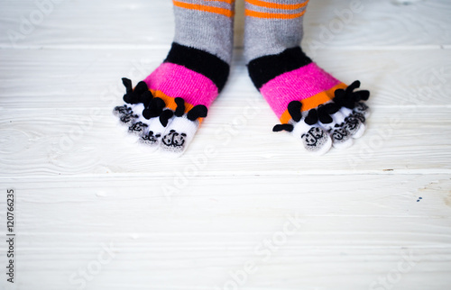 Baby feet in warm, long multicolored socks with toes