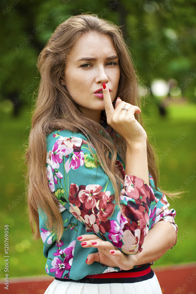 Young beautiful brunette woman has put forefinger to lips as sig Young beautiful brunette woman has put forefinger to lips as sig