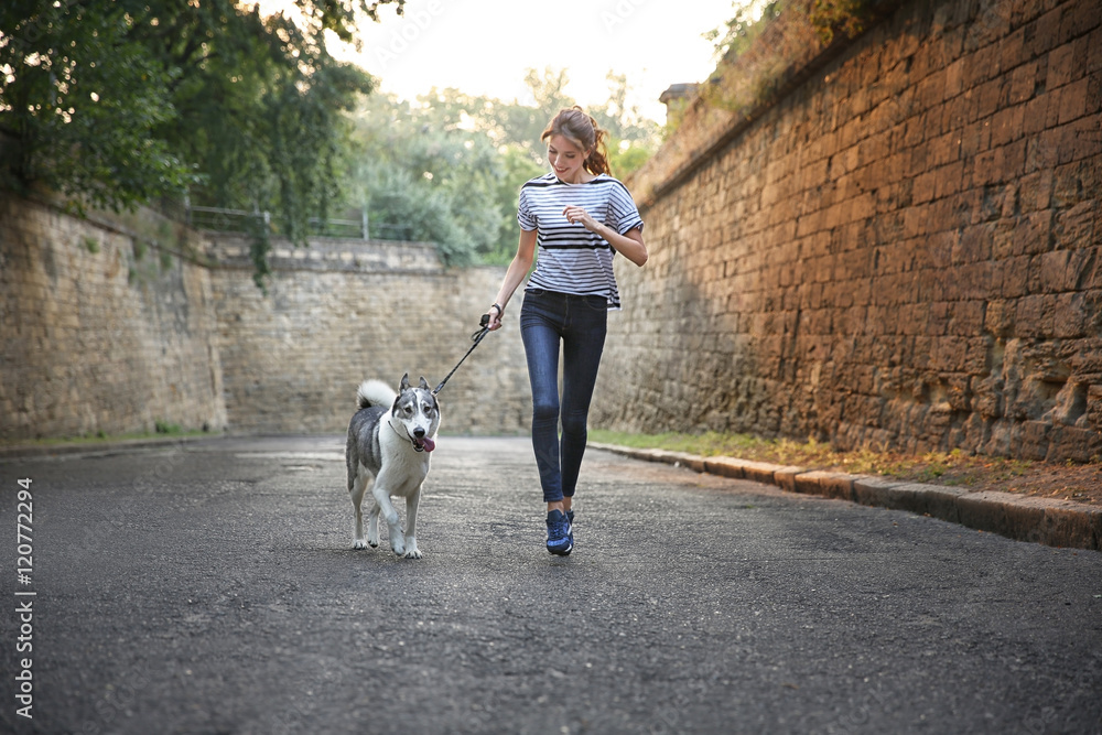 Young beautiful girl with husky running along path Young beautiful girl with husky running along path