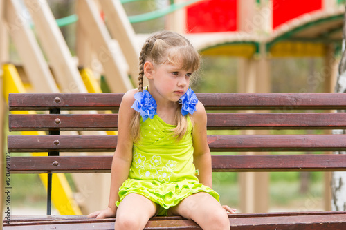 Tablou pe pânză Offended five year old girl sitting on a bench and crying
