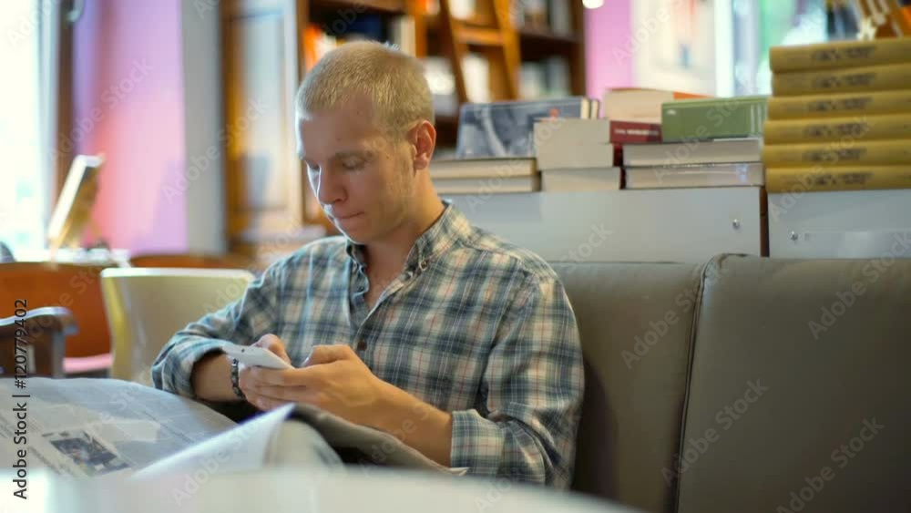 Student texting on smartphone and reading journal in the library
Student texting on smartphone and reading journal in the library