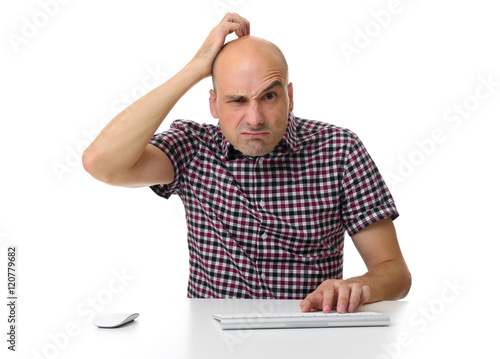 guy working on a computer and scratching his head photo