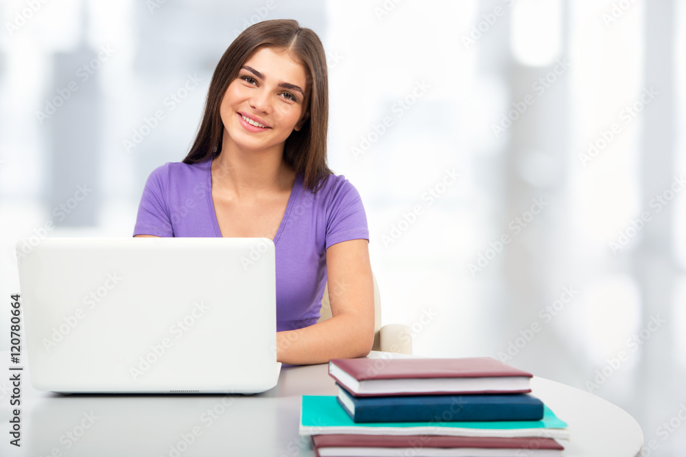 Female student with laptop in a high school library Female student with laptop in a high school library