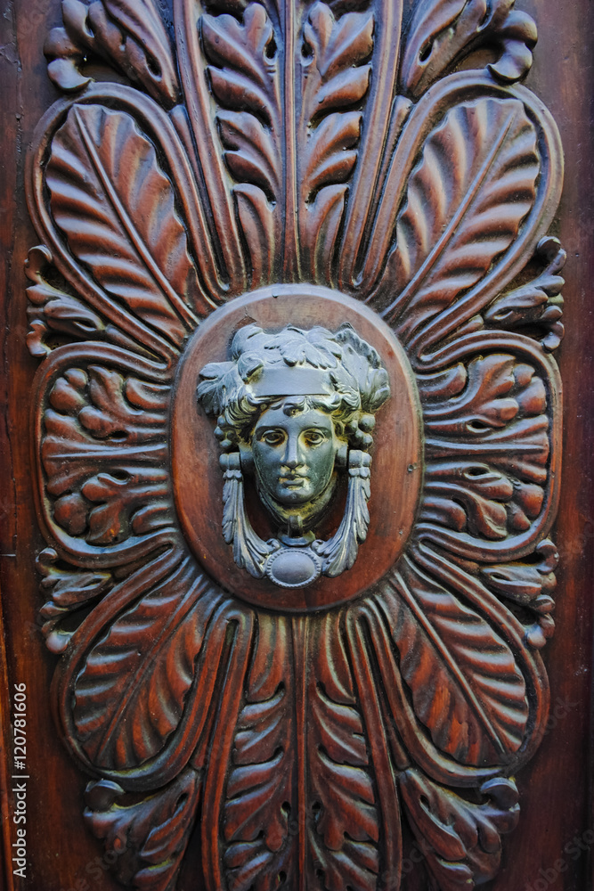 Old ancient door knocker on wooden door