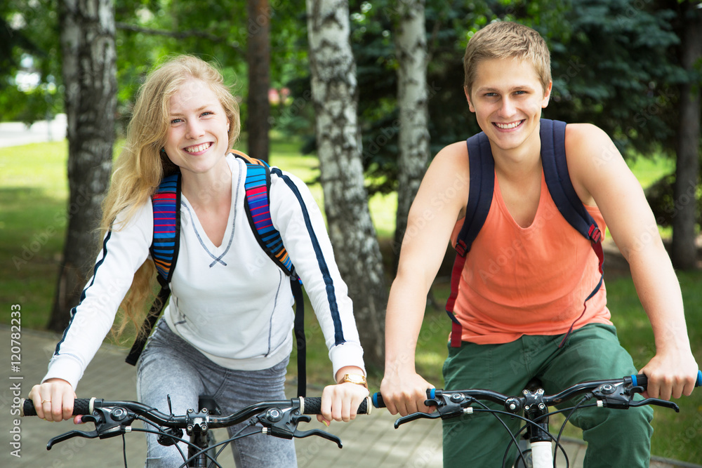 Naklejka premium Young couple riding bicycle outdoors
